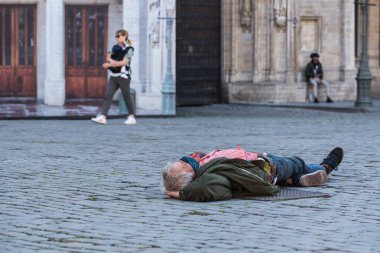 Brüksel Eski Kent, Brüksel Başkent Bölgesi - Belçika - 05: 18 2020 Brüksel Grand Place 'in kaldırım taşlarının üzerinde yatan yaşlı adam