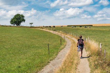Active woman walking through the fields at the countryside, around Burg Reuland East - Belgium