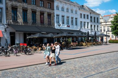 Mechelen, Antwerp Province- Belgium, 07 08 2022 - People walking at the Ijzeren Leen, surrounded by sunny terraces
