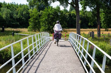 Ulvenhout, North Brabant, The Netherlands, 08 09 2022 - Cyclist driving a bridge over the River Mark