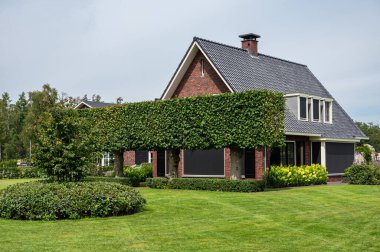 Harskamp, Gelderland, The Netherlands - 07 14 2022 - Country house with front yard, surrounded by trees