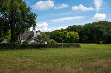 Nature park with green lawn with a country house in the background around Hattem, The Netherlands