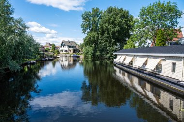 Hasselt, Overijssel, The Netherlands - 07 20 2022 - Houses and apartments reflecting in the water of the river during summer