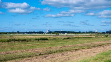 Groningen, The Netherlands, 07 20 2022 - Green fields of the Peizerwering National park with the city of Groningen in the background