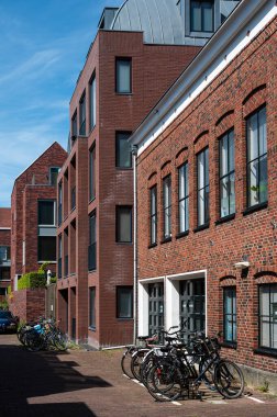 Groningen, The Netherlands, 07 20 2022 - Brick stone facades of residential houses in old town against blue sky
