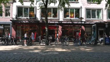 Groningen, The Netherlands, 07 20 2022 - People driving the bike and scooter in the commercial streets of old town