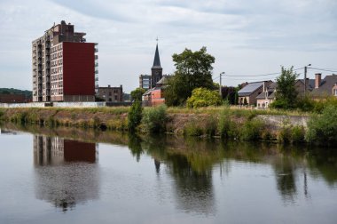 Sambreville, Wallon Bölgesi, Belçika, 07: 30 2022 Sambre Nehri 'ne yansıyan köy binaları.