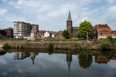 Sambreville, Wallon Bölgesi, Belçika, 07: 30 2022 Sambre Nehri 'ne yansıyan köy binaları.