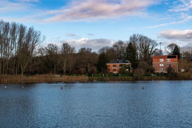 Anderlecht, Brüksel Başkent Bölgesi - Belçika - 12 25 2020 Pede Parkı gölünde renkli kış gökyüzü olan iki tatil evi