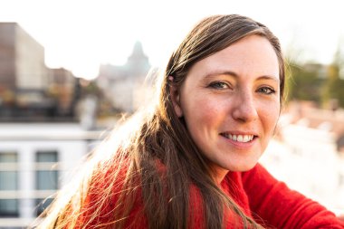 Brüksel 'de çağdaş bir daireye karşı terasta poz veren 30 yaşında çekici beyaz bir kadının portresi.