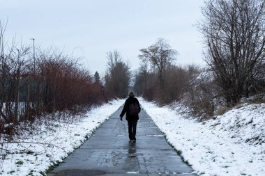 Otuz yaşında bir kadın karda Jodoigne, Belçika 'da Ravel' de yürüyor.