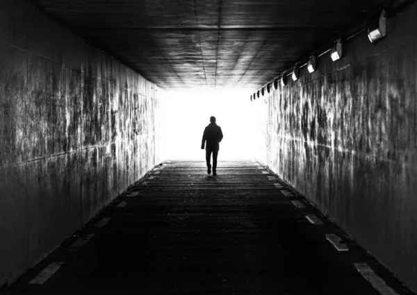 Gent, Flanders, Belçika - 02 20 2021 Karanlık bir tünelde yürüyen bir erkeğin resmi