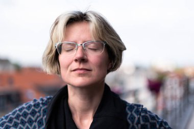 Terasta poz veren çekici bir kadının portresi, gözleri kapalı, Brüksel, Belçika