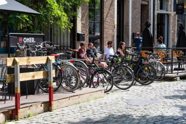 Leuven, Flaman Brabant - Belçika - 06 20 2021 Bisiklet ve güneşli bir terasta öğrenciler