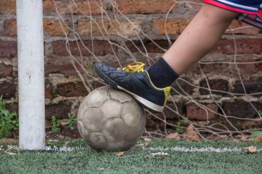 Eski bir futbol topunda çocuk ayağı