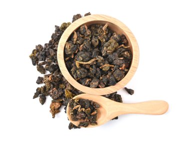 Çin Oolong çayı tahtadan bir kase ve beyaz arka planda izole edilmiş bir kaşıkla GuanYin bağla. Üst görünüm
