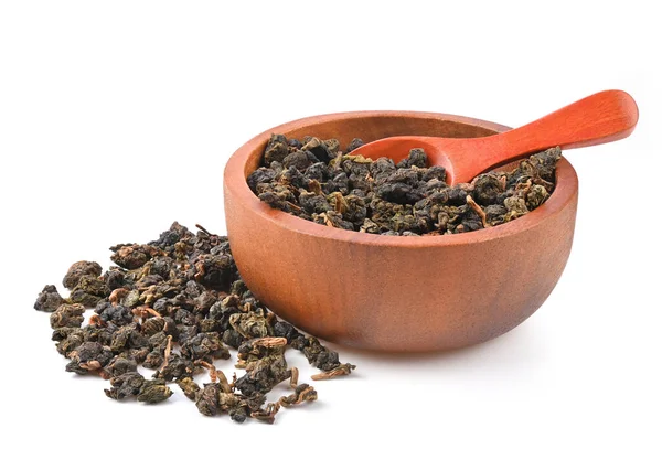 Çin Oolong çayı GuanYin 'i ahşap bir kase ve beyaz arka planda izole edilmiş kaşıkla bağla..