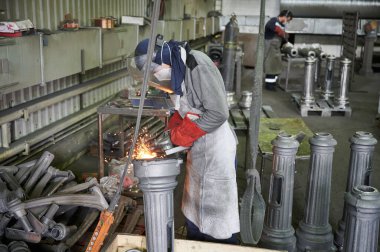 Şehir ışıklandırması için elektrik direği üretimi için üretim hattı. Öğütücü kullanan ürünlerin elle öğütülmesi için bölüm