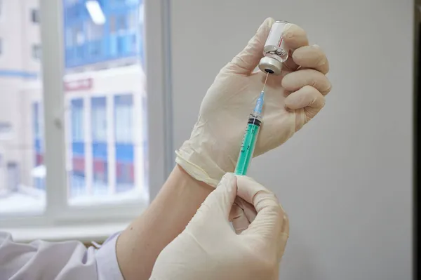 Verpleegkundige vult spuit met vaccin oplossing, bereidt zich voor injectie vaccinatie — Stockfoto