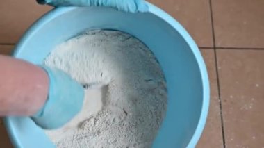 Alçı karışımını normal bir mavi plastik kovayla karıştırarak. Bir malayla.