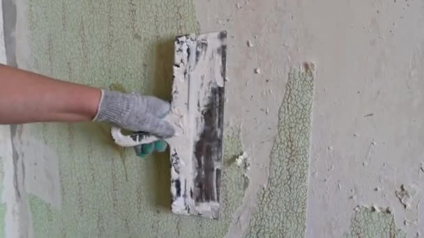 Σκούπισμα παλιά ταπετσαρία από τον τοίχο με σπάτουλες και αυτοσχέδια μέσα, επισκευή ενός διαμερίσματος για τη δική σας — Αρχείο Βίντεο