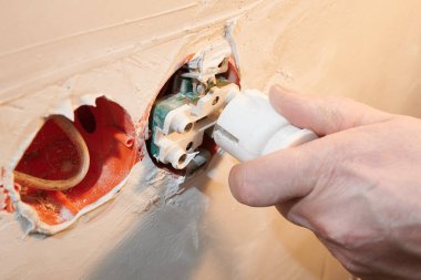 Dekoratif kapağı takılı olmayan yeni bir prize elektrik prizinin tehlikeli bağlantısı