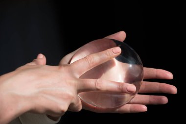 Kalitesini gösterirken kadın göğsünün silikon implantı..