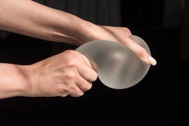 Kalitesini gösterirken kadın göğsünün silikon implantı..