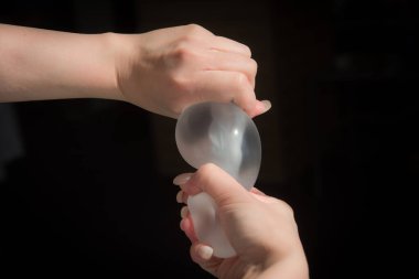 Kalitesini gösterirken kadın göğsünün silikon implantı..