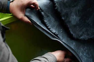 Fabrikadaki lastik ürünlerin üretiminin ilk aşamalarından biri. Hammadde dikiş dokusuna yakın çekim. Orta boy toptan üretim teknolojisi.