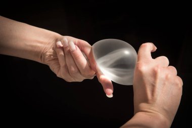 Kalitesini gösterirken kadın göğsünün silikon implantı..