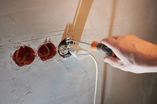 Gefährlicher Anschluss einer Steckdose an eine neue Steckdose ohne dekorative Abdeckung auf frisch verputzter Wand — Stockfoto
