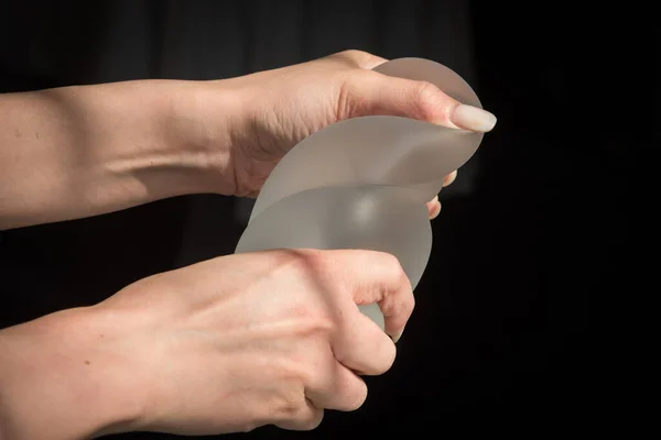 Implante de silicona de la mama femenina durante la demostración de su calidad. — Foto de Stock