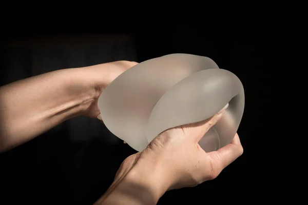 Силиконовый имплантат женской груди во время демонстрации ее качества. Стоковое Изображение