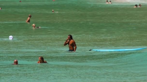 Oidentifierad surfare och turister i vågorna — Stockvideo