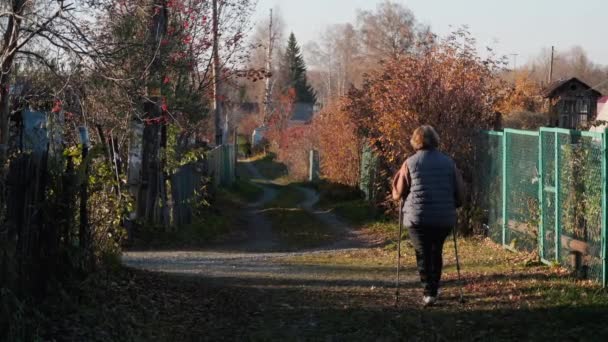 Mulher andando com paus de caminhada nórdicos — Vídeo de Stock