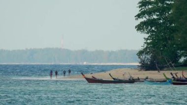 İnsanlar sahil boyunca yürür