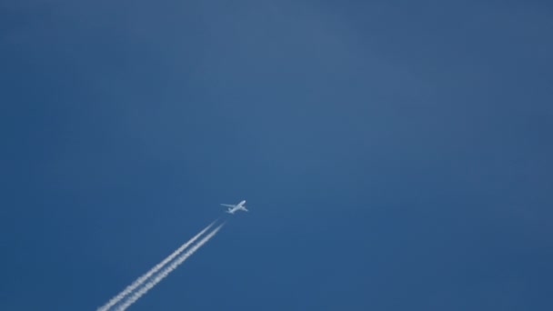 En lo alto del cielo un avión y un sendero — Vídeo de stock