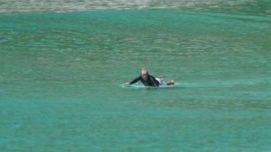 PHUKET, THAILAND - 20 Kasım 2018: Phuket 'te güneş gününde suda sörf yapan adam. Panorama deniz manzarası ve spor aktiviteleri