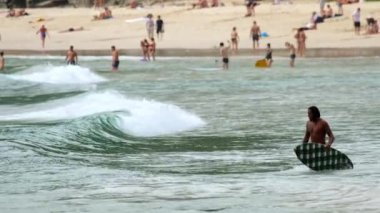 Sörfçüler Nai Harn Sahili, Phuket Tayland 'da dalgaların tadını çıkarırlar.