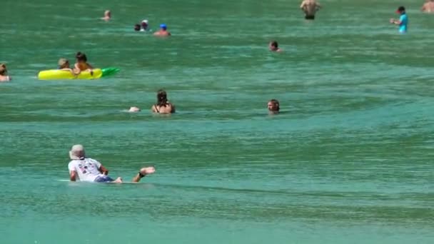 Surfista não identificado e turistas nas ondas — Vídeo de Stock