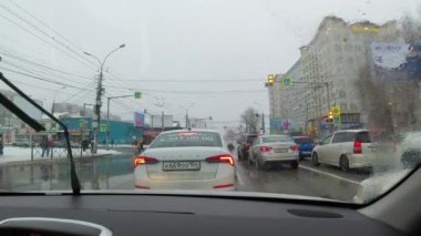 Şehir sokaklarına kar ve yağmur yağıyor.