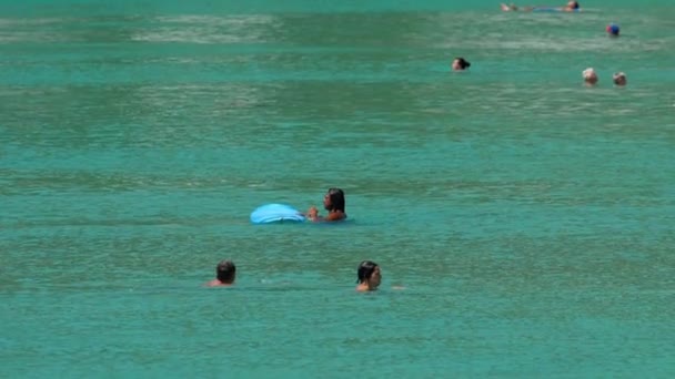 Нерозпізнаний серфер і туристи у хвилях — стокове відео