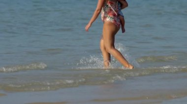 Kumsalda bebekli bir kadın.