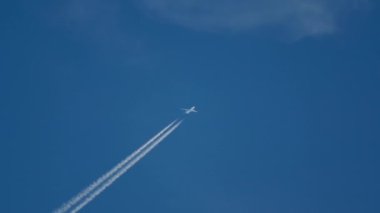 Mavi gökyüzünde uçak izleri var.