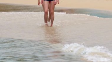 İnsanlar deniz kıyısında yürür