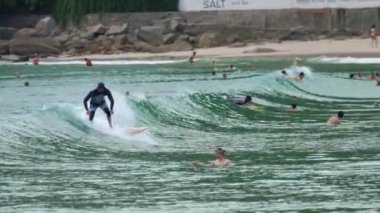 Sörfçüler Nai Harn Sahili, Phuket Tayland 'da dalgaların tadını çıkarırlar.