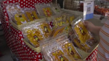 Kadın kurutulmuş mango alır.