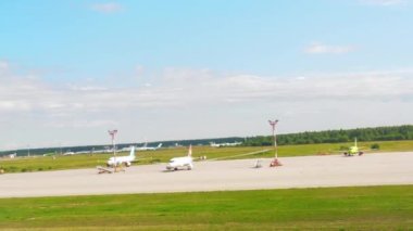 Havaalanına iniyor, pencereden bakıyor.