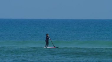 Okyanustaki SUP panosundaki kız.